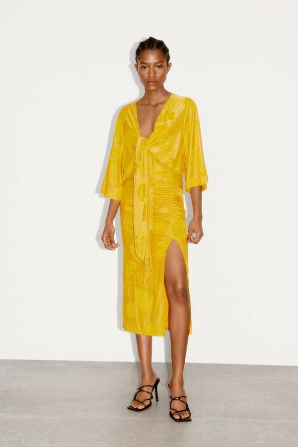 Body en tejido jacquard con estampado a tono luminoso color amarillo, escote de pico, manga fluida por debajo del codo y detalle de nudo delantero. Cuesta 22,95 euros.