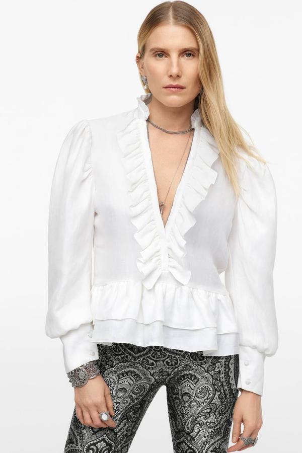 Blusa Limited Edition con cuello redondo, escote de pico, manga larga abullonada terminada en puño y decoraciones de volantes, color blanco, de Zara.