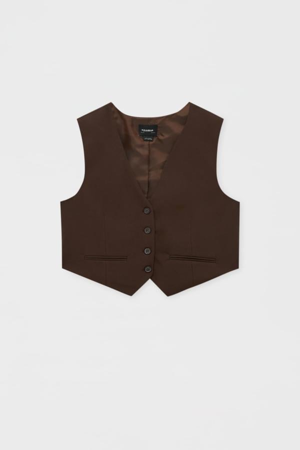 Chaleco de vestir en color marrón chocolate con cierre de botones en la parte delantera. Es de Pull&Bear. Precio: 12,99 €. 