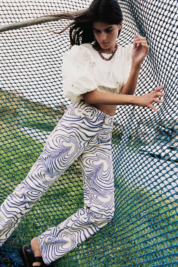 Vaqueros tipo straight de tiro alto, pernera recta y suelta, cinco bolsillos y estampado de ondas en color blanco y azul marino, de Zara.