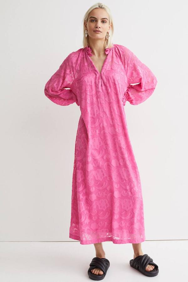 Vestido largo estilo túnica de tejido estampado con textura, cuello redondo con volante y abertura en v, mangas largas tipo globo y silueta amplia y recta. Cómpralo a 49,99 euros.