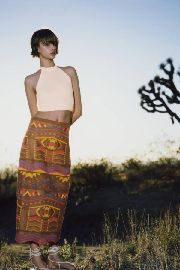 Falda larga confeccionada en tejido de lino decorado con bordados étnicos, tiro alto, corte recto y bajo terminado en zigzag con abertura posterior, color marrón, de Zara. Cuesta en rebajas 25,99 euros.