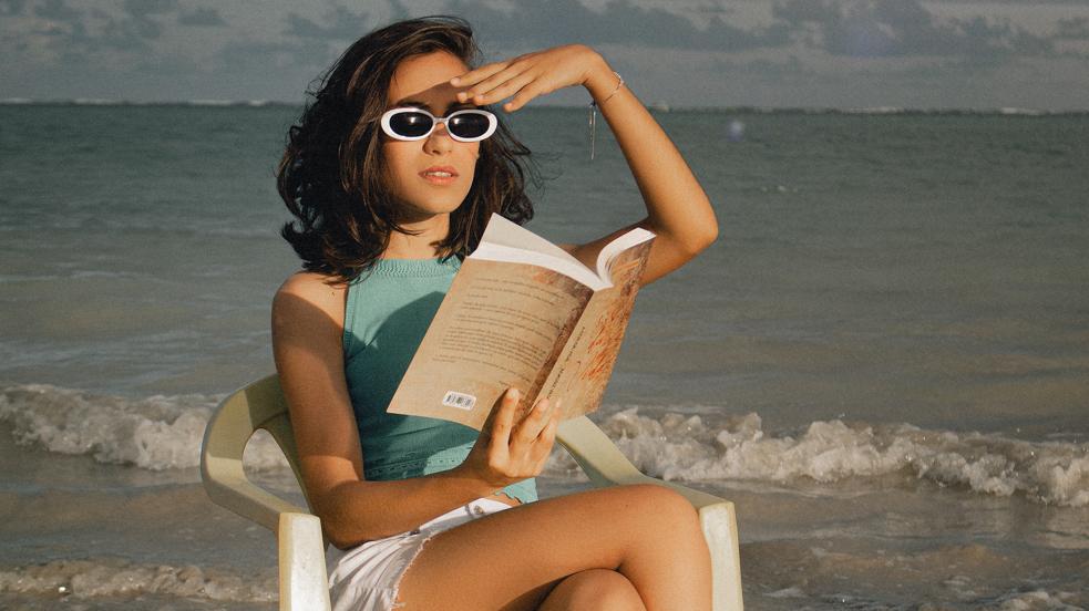 Mujer leyendo en la playa. 