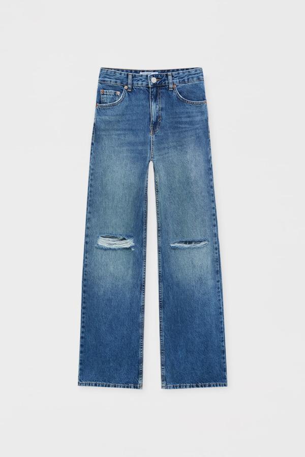 Jeans campana de tiro alto con detalle de rotos, diseño de cinco bolsillos, cintura con trabillas. Cierre de cremallera y botón. Es de Pull&Bear. Precio rebajado: 15,99 €. 