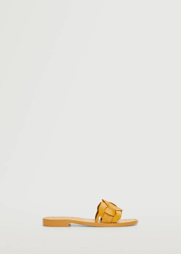 Las vacaciones son el momento perfecto para aparcar los tacones y rendirse ante los encantos del calzado plano. Las sandalias trenzadas son la opción más cómoda y estilosa. Sandalias color mostaza de Mango (29,99 euros)
