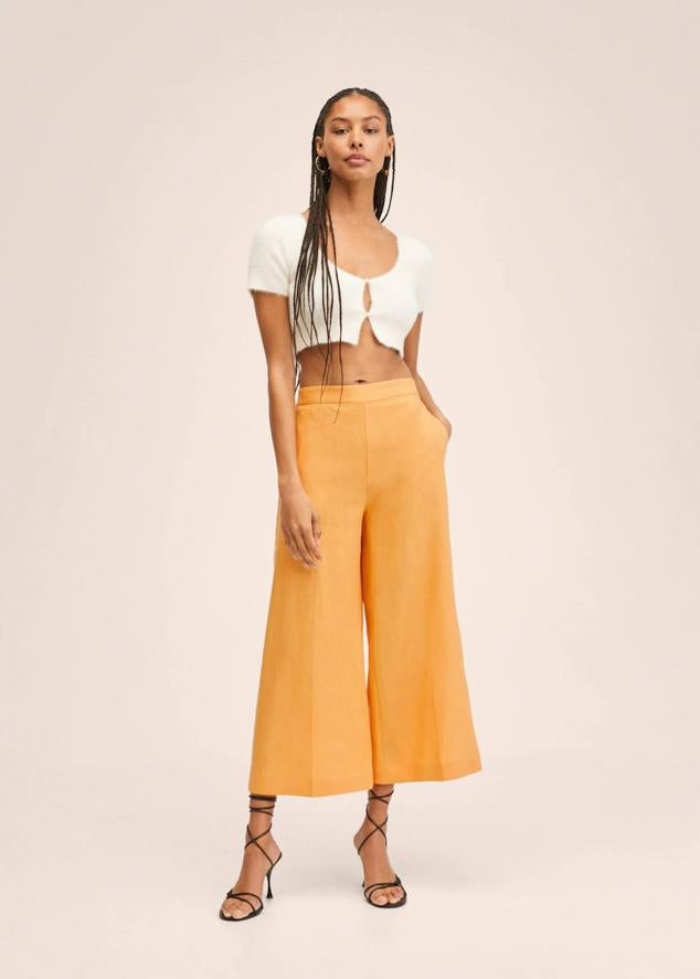Pantalón culotte en tejido 100% de lino con turo alto, elástico en la parte posterior de la cintura y bolsillos laterales, color naranja, de Mango. Están rebajados a 19,99 euros.