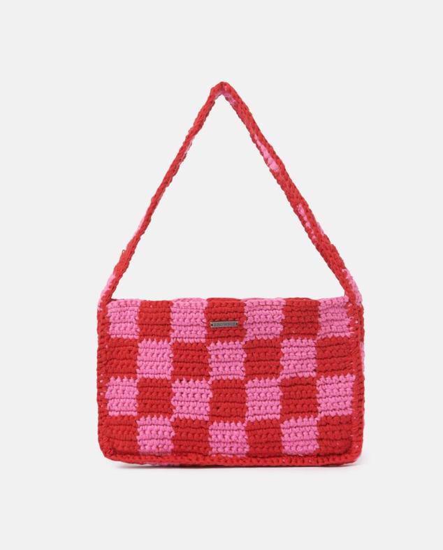 Bolso de hombro en tejido de crochet bicolor fucsia y rojo, con motivos de cuadros y cierre de imán y forro a tono, de Brownie. Cuesta 19,90 euros rebajado.