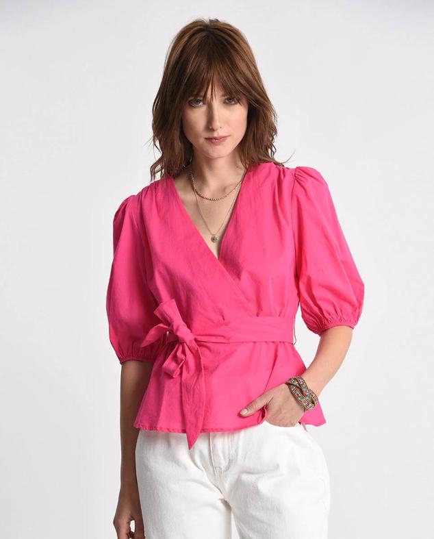 Blusa de diseño cruzado con manga corta abullonada, escote de pico y detalle de cinturón de lazada a juego, en fucsia, de Molly Bracken. La encontrarás rebajada en El Corte Inglés a 30,20 euros.