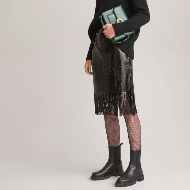 De diseño recto y en color negro, tiene lentejuelas con flecos en su acabado. Se trata de un modelo de talle alto, con cierre de cremallera en la espalda y corte estándar. Es de La Redoute. Precio rebajado: 38,49 €.