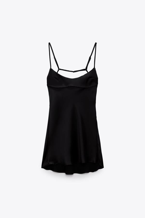 Vestido corto satinado de escote recto. Sus tirantes aportan un toque sexi al look que dejan la espalda descubierta. Es de Zara. Precio: 25,95 €.