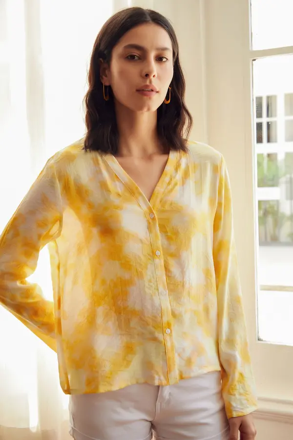 Blusa de corte recto con escote de pico con botonadura frontal. Su estampado tie dye amarillo se convertirá en el favorito de tu armario. Es de If Yoou. Precio: 21,99 €.