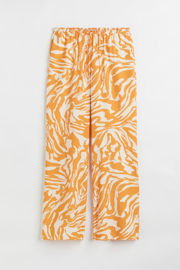 Este pantalón con estampado estival es todo lo que necesitas para cualquier look veraniego. Su color hace posible que tu bronceado luzca más luminoso. Es de H&M. Precio: 24,99 €.