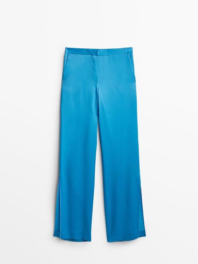 Pantalón satinado de color azul océano, aunque también está disponible en mandarina. Destaca por sus aberturas en los bajos. Ideal para llevarlo con deportivas o plataformas. Es de Massimo Dutti. Precio: 69,95 €.