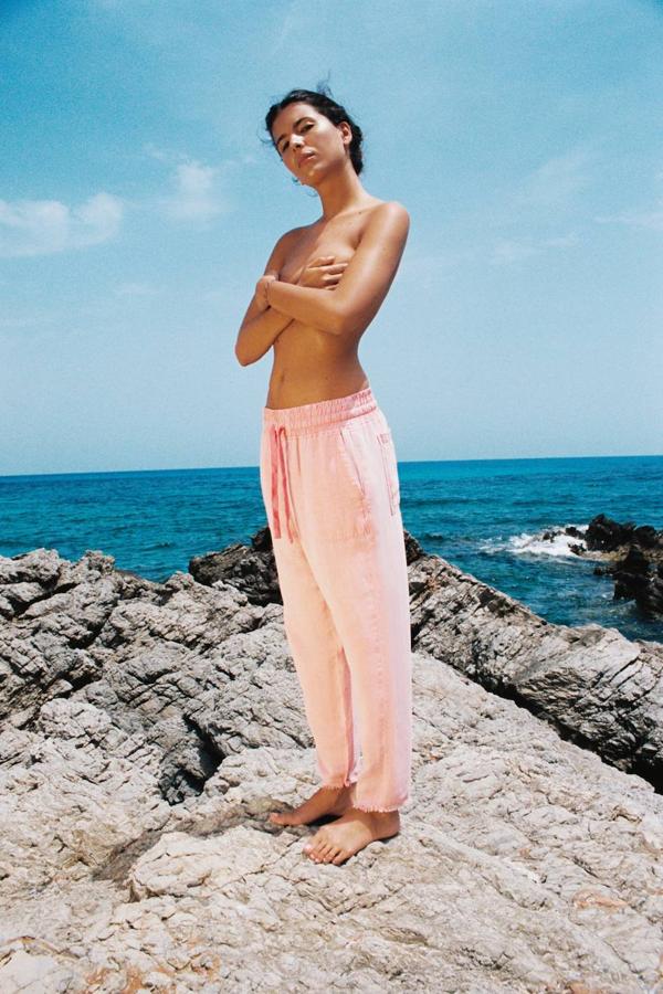Pantalón jogger con lino, tiro alto con cintura elástica ajustable, bajo desflecado y bolsillos de plastrón, en tono rosa claro, de Zara. Están disponibles a 29,95 euros.