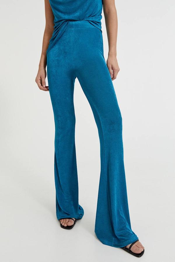 Pantalón en tejido fluido y elástico con tiro alto y pernera flare terminada en maxi campana, color azul pato o púrpura, de Pull&Bear. Cómpralo rebajado a 9,99 euros.