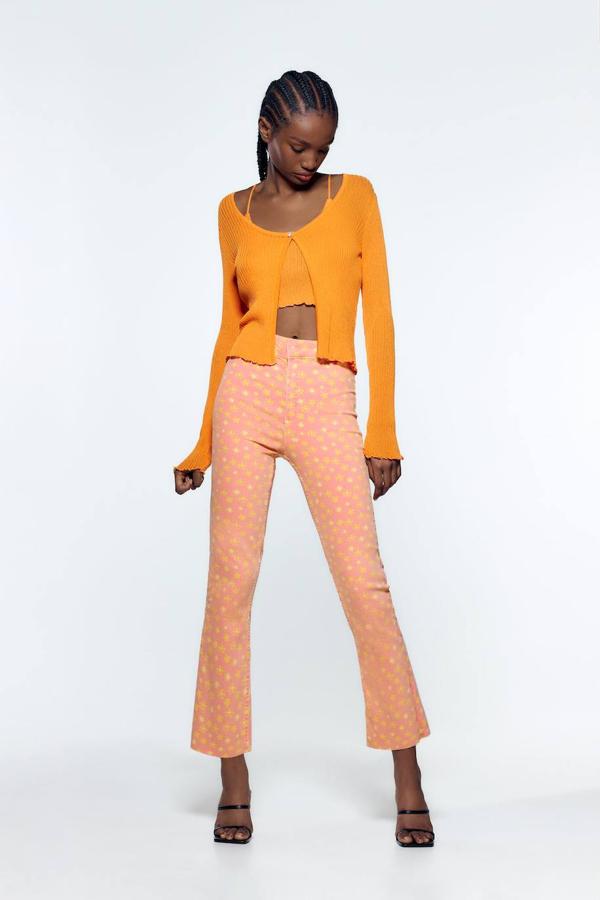 Jeans flare con pernera cropped, tejido super elástico, tiro alto, diseño de cinco bolsillos y estampado de flores en rosa y naranja, de Zara. Está disponible en rebajas a 7,99 euros.