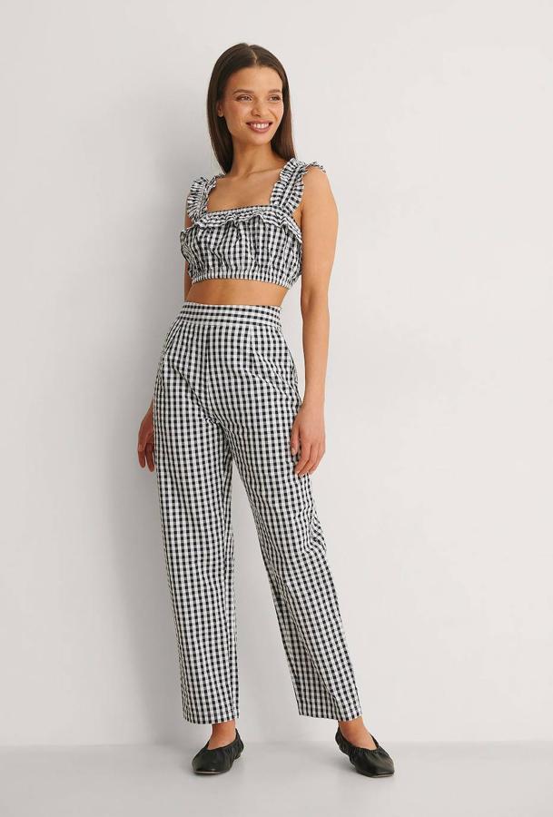 Pantalón en estampado de cuadros vichy con tiro alto, diseño cropped y pernera holgada, de NA-KD. Cuestan 12,78 euros rebajados. Cómpralo aquí