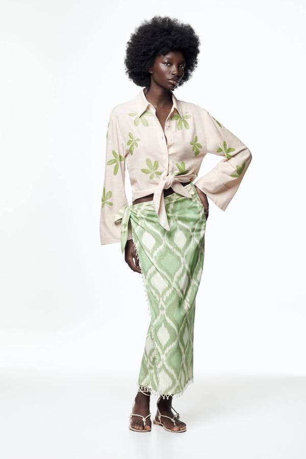 Falda mi estampada con tiro alto, diseño cruzado, silueta recta, lazada lateral y aplicación de cuentas a tono en las terminaciones, color verde, de Zara. Cuesta 39,95 euros.