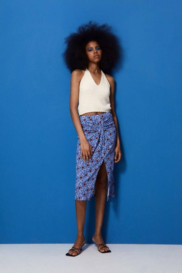 Falda midi de tiro alto con detalle fruncido en la cintura, abertura frontal en el bajo y estampado, color azul, de Sfera. Puede comprarla a 13,99 euros.