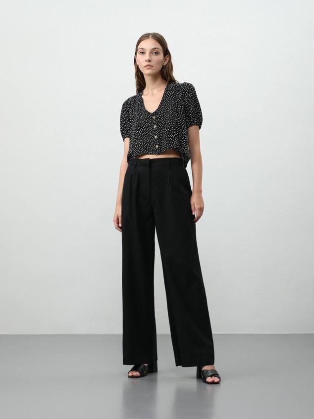 Pantalón de vestir masculino con tiro alto, detalle de pinzas, trabillas para el cinturón y bolsillos laterales. Los puedes comprar en negro, blanco o fucsia, a 17,99 euros.