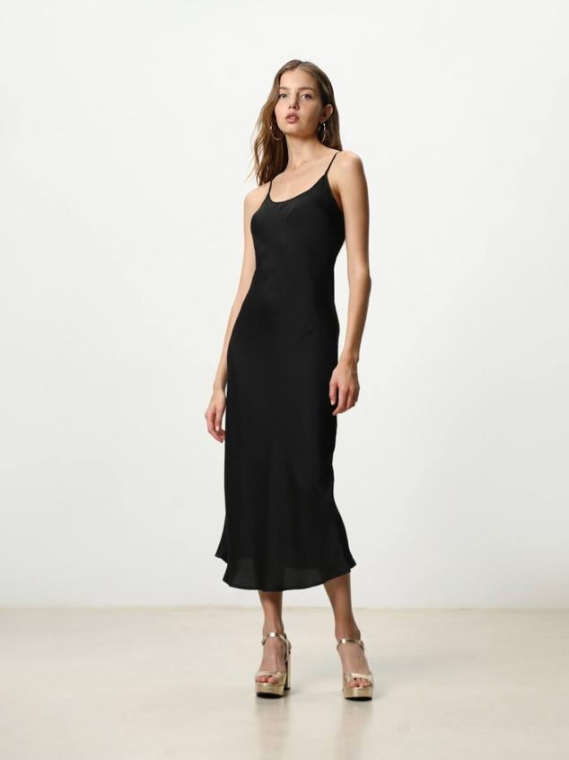 Vestido largo estilo lencero con tejido satinado, tirantes y escote redondo, color negro. Tiene un precio de 15,99 euros.
