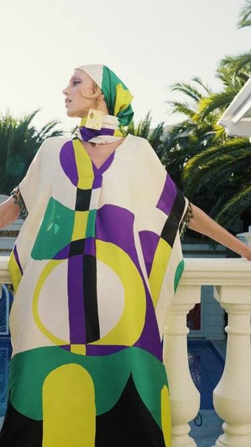 Caftán midi con estampado abstracto en crudo, morado, verde y negro, escote de pico, manga corta y detalle de abalorios colgantes. Lo encontrarás a 59,95 euros.