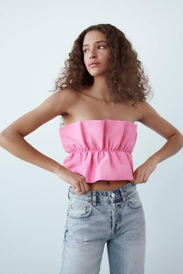 Top bandeau con escote recto, hombros al descubierto y tejido fruncido con volumen, color rosa. Tiene un coste de 15,95 euros.