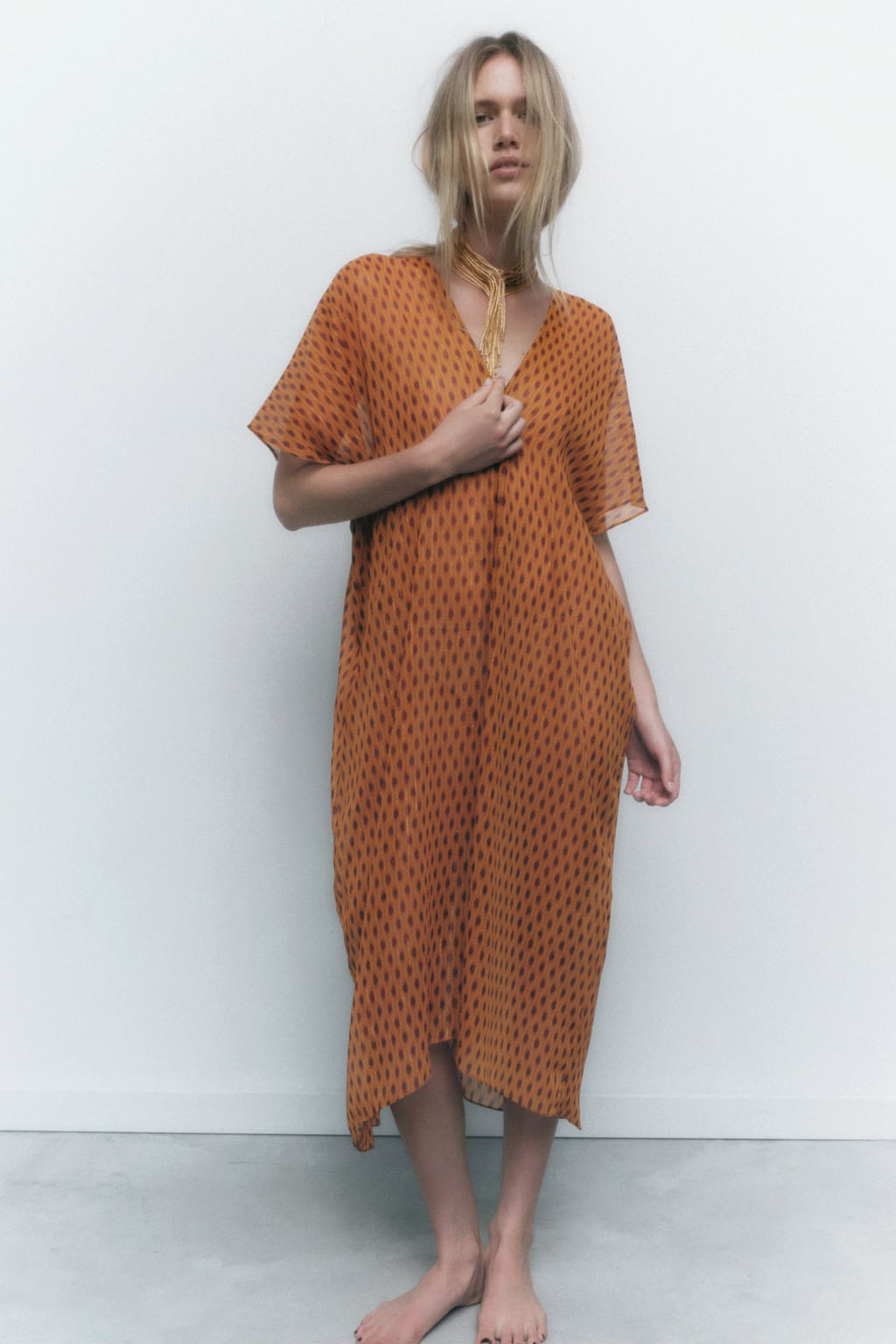 Un color entre el naranja y el terracota que favorece mucho a las pieles bronceadas. Vestido midi con estampado geométrico de Zara (39,99 euros). 