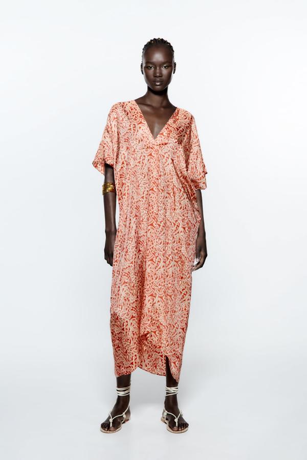 El corte midi es perfecto para este tipo de túnicas que podrás lucir dentro y fuera de la playa. Vestido estampado en tejido fluido de Zara (39,99 euros). 