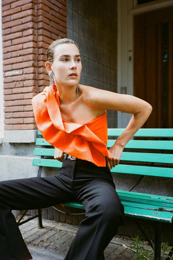 Y el premio al top más original y vistoso de la nueva temporada de Zara es para este diseño asimétrico con maxi volante en color naranja. (12,99 euros). 