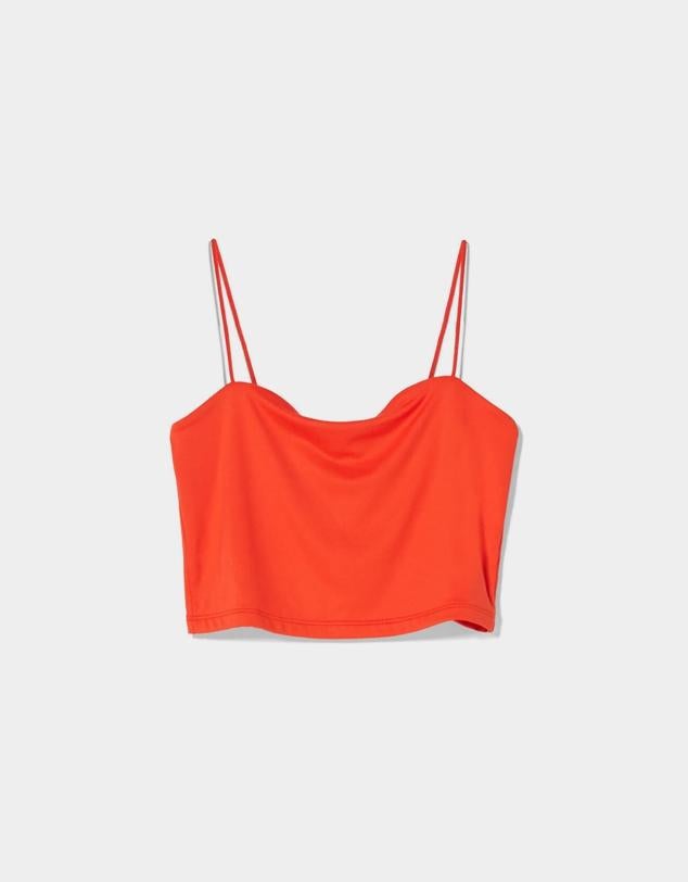 Top en versión cropped de tirantes diseñado en un color rojo vibrante para potenciar aún más el bronceado. Es de Bershka. Precio: 5,99 €.