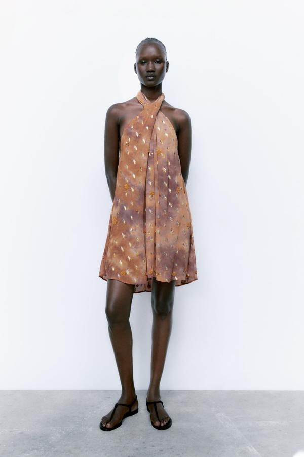 Vestido corto de cuello halter cruzado ajustable con lazadas en espalda. Confeccionado con abalorios para generar un estilismo sofisticado y elegante. Es un diseño edición limitada. Es de Zara. Precio: 69,95 €.