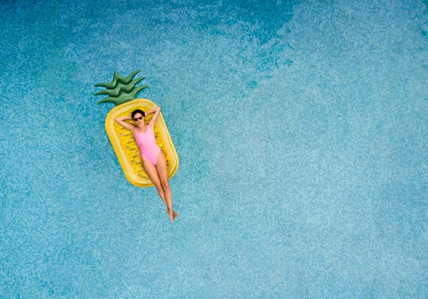 Carefree woman on inflatable pineapple