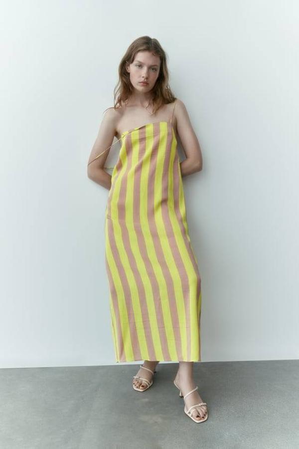 Zara nos trae este vestido de corte midi en color amarillo flúor que tiene unos tirantes muy finos.