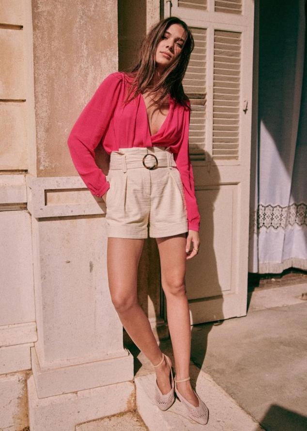 La versión más elegante de esta pequeña prenda es de lino y lleva un cinturón del mismo tejido. Shorts en color beige con cinturón a juego de Sezane (95 euros). 