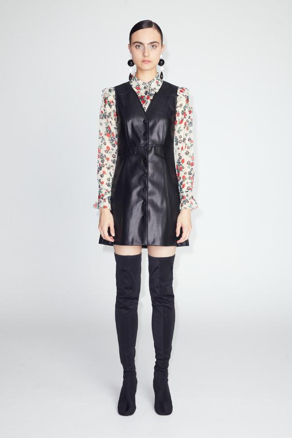 Vestido corto tipo pichi con efecto piel. Manga sisa y cuello en pico, ideal para llevar con una camisa de cuello solapa debajo, como se ve en la imagen. Precio: 35,99 euros.