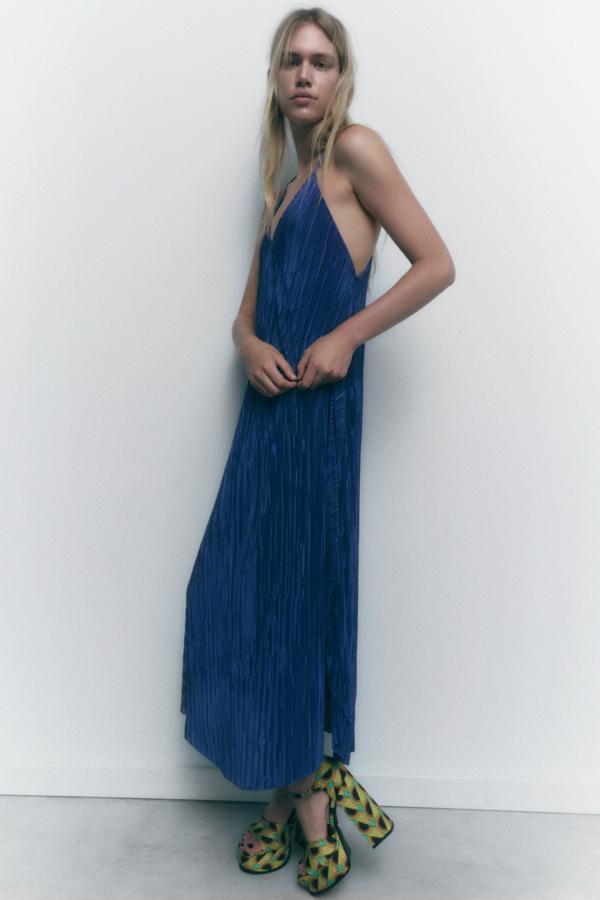 Vestido midi plisado con escote pico y tirantes finos cruzados en espalda. Un diseño perfecto para llevártelo a las vacaciones o ir a la oficina. Es de Zara. Precio: 25,95 €.