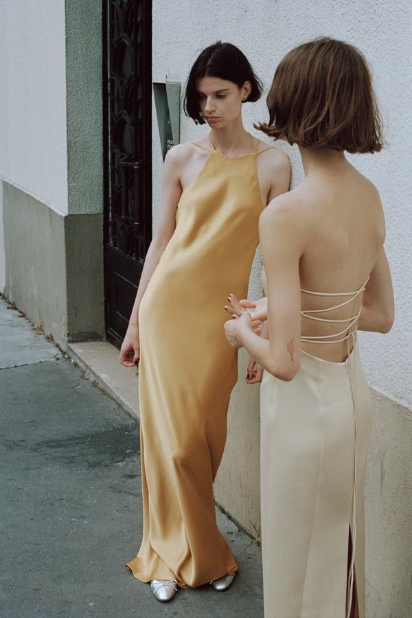 Los vestidos de aire lencero son perfectos para las grandes celebraciones de la recta final del verano. Vestido con ecote halter en color champagne de Zara (49,99 euros): 
