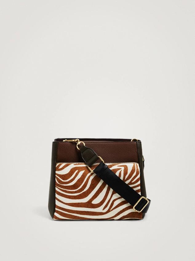 Bolso de hombro mediano en tejido de piel, con bolsillo delantero con cremallera, asa bandolera ajustable y detalle de animal print, en marrón. Su precio es de 32,99 euros.