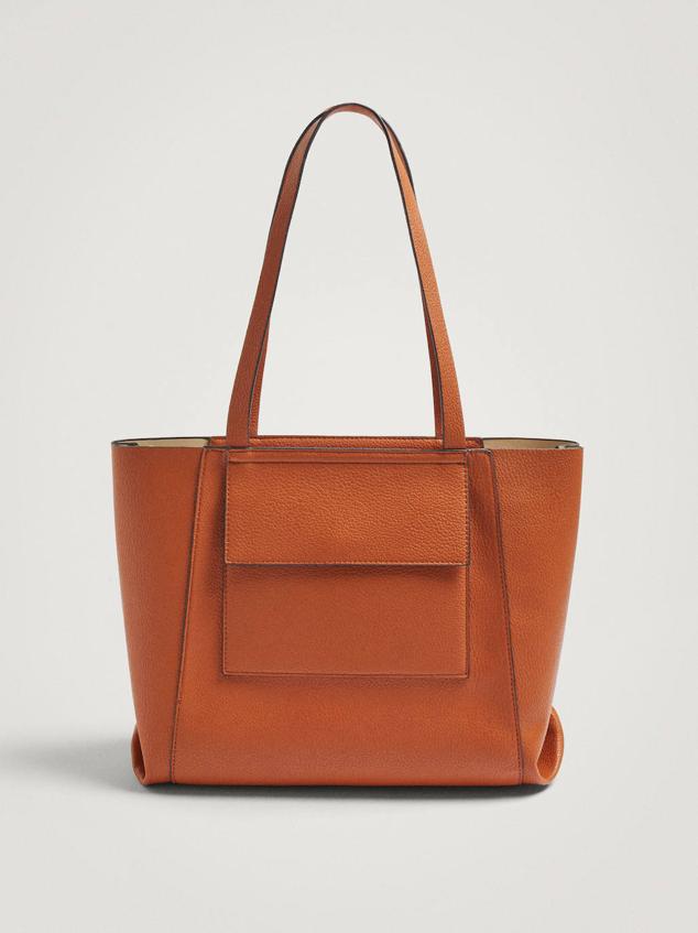 Bolso shopper grande en tejido efecto piel con doble asa de hombros, dos bolsillos grandes en el exterior y cierre de cremallera. Lo encontrarás en camel y crudo, a 25,99 euros.