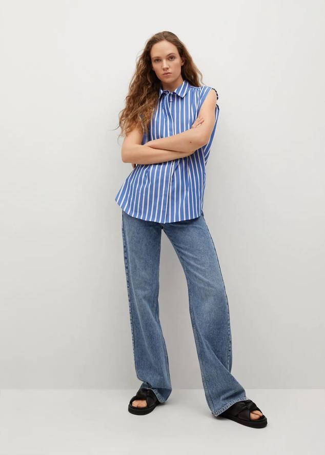 Es una camisa básica con estampado de rayas en color azul y blanco. No cuenta con mangas y es de popelín. Cuenta con un estilo oversize y cuello camisero. Ahora está rebajada a 11,99 euros y también está disponible en versión lisa, sin rayas.