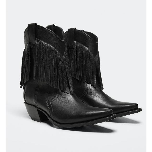 Botín de estilo cowboy elaborada en piel. Con punta y flecos decorativos,cuenta con costuras decorativas. De caña media y tacón de 5,5 centímetros. Precio: 249,99 euros en Mango.