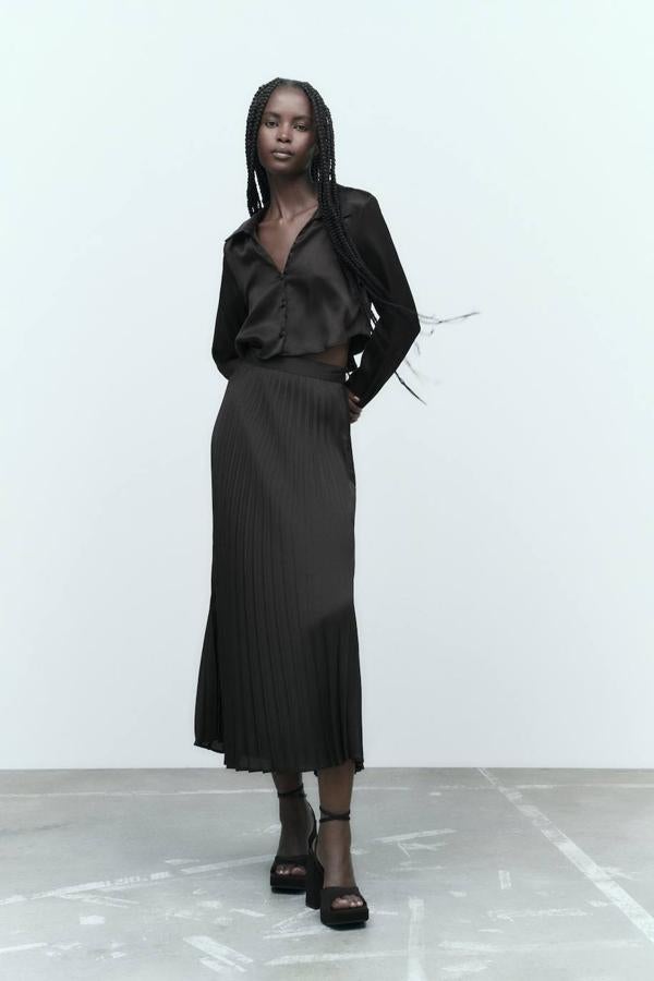 Falda midi en tejido plisado con talle alto y bajo acabado en evasé, de Zara. Tiene un coste de 25,95 euros.