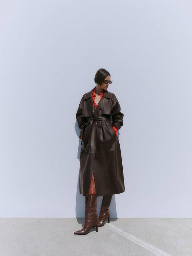 Trench confeccionado en piel bovina con cuello solapa, detalles de trabillas, bolsillos y cinturón de lazada, en marrón oscuro, de Massimo Dutti. Cuesta 399 euros.