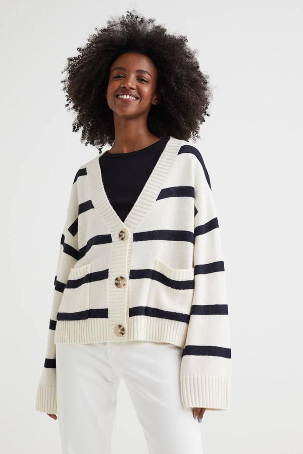 Cárdigan de punto suave con diseño boxy, escote de pico, manga larga, silueta amplia, bolsillos, cierre de botones y estampado de rayas en azul y blanco, de H&M. Su coste es de 29,99 euros.