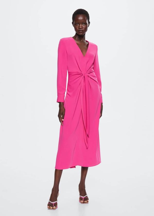Hay un diseño que está causando sensación entre todas las invitadas de boda. Un vestido de corte midi, manga larga y drapeados en la cintura. Vestido rosa fucsia de la nueva colección de Mango (49,99 euros). 