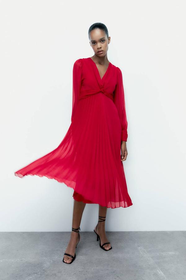 Vestido midi en tejido vaporoso plisado con escote de pico con nudo y manga larga ligeramente abullonada, tono fucsia, de Zara. Lo encontrarás a 39,95 euros.