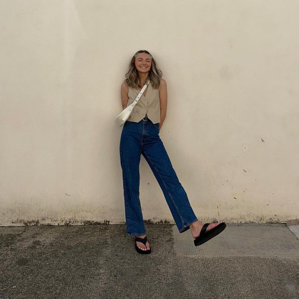 La influencer escandinava Chloe Hayward con unos vaqueros de talle alto y un chaleco de color verdoso. 