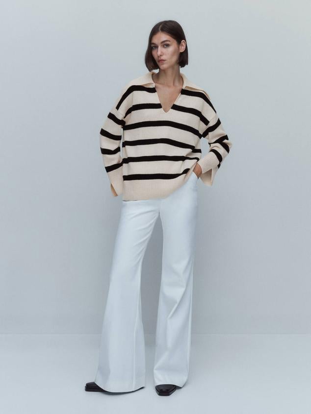 Jersey ancho en cashmere con silueta relajada, manga larga, cuello polo y escote de pico, en estampado de rayas negro y crudo, de Massimo Dutti. Cómpralo por 69,95 euros.