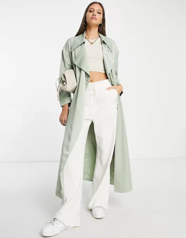 Gabardina de diseño extragrande en color salvia con solapas de muesca, sisas caídas y lazada en la cintura. Precio: 69,99 euros en Asos. Cómpralo aquí